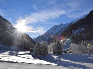 a snow covered mountain with the sun shining through the mountains at Lovely Holiday Home in Mayrhofen with Garden and Whirlpool in Mayrhofen