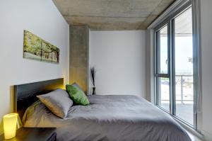 A bed or beds in a room at Les Immeubles Charlevoix - Le 760605