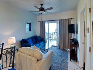 a living room with a couch and a tv at Baywatch #B1 in Pensacola Beach