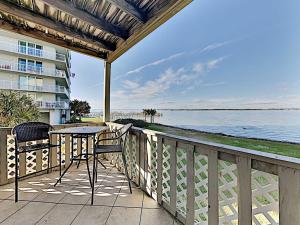 a balcony with a table and chairs and a view of the water at Baywatch #B1 in Pensacola Beach
