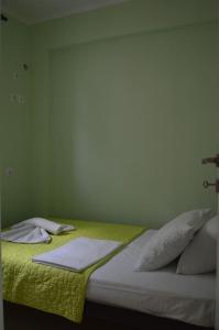 un letto con una coperta gialla e cuscini sopra di Almiriki a Elafónisos