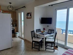 a dining room with a table and chairs and the ocean at Almiriki in Elafonisos