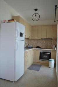 uma cozinha com um frigorífico branco e um fogão em Almiriki em Elafonisos