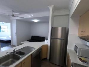 a kitchen with a stainless steel refrigerator and a sink at Aruba Surf Resort in Gold Coast