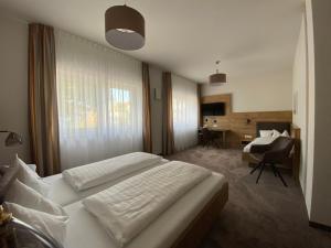 een hotelkamer met een bed en een bureau bij Hotel-Pension Scharl am Maibaum in Eitting
