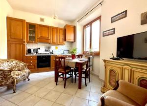 a kitchen with a table and a dining room at Dimora delle Mura in San Quirico dʼOrcia