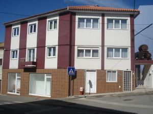 un edificio rojo y blanco al lado de una calle en Live Oeste, en Bombarral