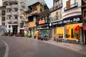 a city street with motorcycles parked in front of buildings at Queen Cafe Hotel & Pub in Hanoi