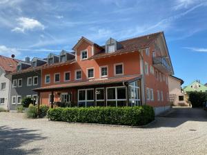 a large red building with a lot of windows at Hotel-Pension Scharl am Maibaum in Eitting