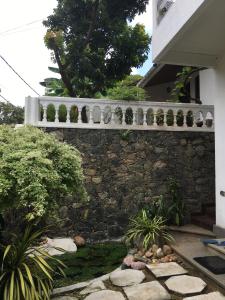 a stone retaining wall with a pond in front of a house at Bolgoda wind 