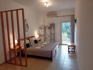 a bedroom with a bed and a large window at DANDOLOS STUDIOS in Parga