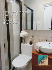 een badkamer met een wit toilet en een wastafel bij "El Nissi's Cozy Staycation" Beside Enchanted Kingdom in Malamig