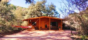 a log cabin with a hammock in front of it at CABAÑAS DEL BOSQUE CERCA DE CORDOBA in Córdoba