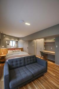 a bedroom with a large bed and a blue couch at ZDT-511 in Tokyo