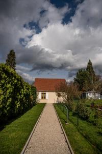 een wit huis met een rood dak en een loopbrug bij Gite Pak'Home maison à la campagne 3 étoiles avec wifi in Lombray