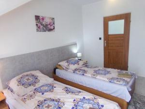 two beds in a small room with a door at Motel Anna Serafin in Radom