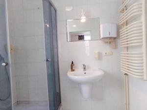 a white bathroom with a sink and a shower at Motel Anna Serafin in Radom