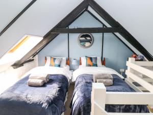 two beds in a room with a attic at Sun Rise Cottage in Saundersfoot