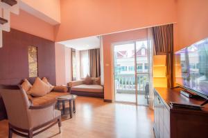 a living room with a couch and a television at Grand Pacific Sovereign Resort & Spa in Cha Am