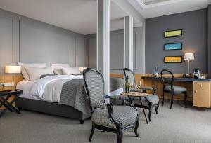 een slaapkamer met een bed, een bureau en stoelen bij Hotel Wassersleben in Flensburg