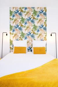 1 dormitorio con cama blanca y papel pintado tropical en Perle de la somme - Parking - Gare d Amiens, en Amiens