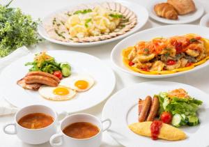 a table with plates of food and cups of coffee at APA Hotel & Resort Tokyo Bay Shiomi in Tokyo