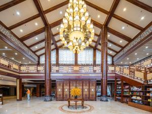 a large library with a chandelier and a table in the middle at S&N Hotel Sanqingshan in Shangrao