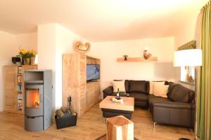 sala de estar con sofá y chimenea en 5 Sterne Ferienwohnung Bergahorn mit Sauna, en Oberstaufen