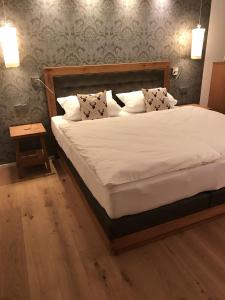 ein Schlafzimmer mit einem großen Bett mit weißer Bettwäsche und Kissen in der Unterkunft 5 Sterne Chalet Bergsuite in Oberstaufen
