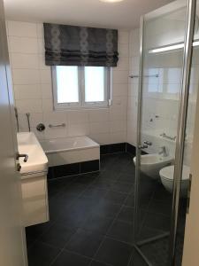 a bathroom with a tub and a sink and a toilet at 5 Sterne Chalet Bergsuite in Oberstaufen