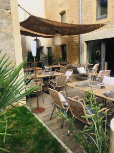 a patio with tables and wicker chairs and tables and a building at La Cambrousse 