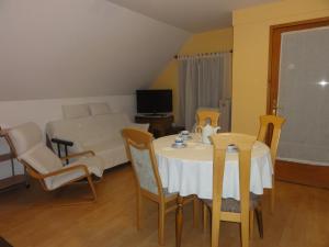 sala de estar con mesa, sillas y cama en Apartment Makuc, en Bovec