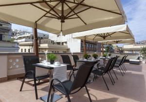 a patio with tables and chairs and umbrellas at Relais Villa Coppedè in Rome