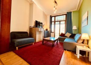 een woonkamer met een bank en een stoel bij Cozy, comfortable apt, well located - EU ULB VUB in Brussel
