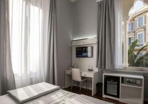 a bedroom with a bed and a desk and a window at Relais Villa Coppedè in Rome