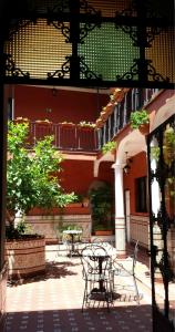 eine Terrasse mit Tischen und Stühlen in einem Gebäude in der Unterkunft Al Andalus Jerez in Jerez de la Frontera