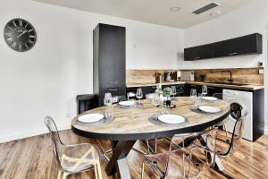 a kitchen with a table with chairs and a clock at Appartement Le Somptueux Bressan - Hyper-Centre in Bourg-en-Bresse