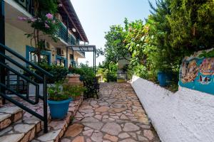 a stone walkway in front of a building with potted plants at Andromaches sea view studio 3 in Achílleion
