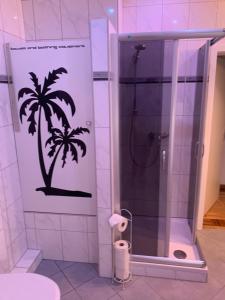 a bathroom with a shower with a palm tree stencil on the wall at Großes Apartment Aschaffenburg 4 Schlafzimmer bis zu 10 Personen Mainpark Apartment Mainaschaff in Mainaschaff +86 photos