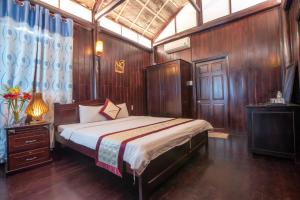 a bedroom with a bed and a wooden wall at Hung Vuong Resort in Phu Quoc