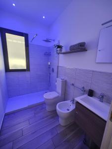 a bathroom with a toilet and a tub and a sink at B&B CESARE'S Guests in Acitrezza