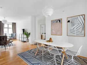 ein Wohnzimmer mit einem weißen Tisch und Stühlen in der Unterkunft Sanders Constantin - Chic Two-Bedroom Apartment With Balcony in Kopenhagen