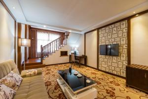 ein Wohnzimmer mit einem Sofa und einem Flachbild-TV in der Unterkunft S&N Hotel Sanqingshan in Shangrao