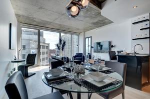 a dining room and living room with a table and chairs at Les Immeubles Charlevoix - Le 760610 in Quebec City