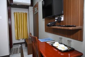 a room with a dining table and a television at HOTEL COSTA LAND in Port Blair