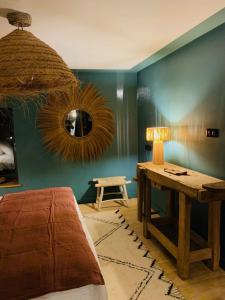 a bedroom with a bed and a table and a mirror at La Cambrousse 