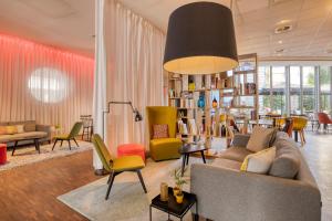 ein Wohnzimmer mit einem Sofa und Stühlen in der Unterkunft Holiday Inn Express Mechelen City Centre, an IHG Hotel in Mechelen