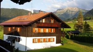 una casa in un campo con montagne sullo sfondo di Ferienwohnung Bergsonne mit Oberstaufen Plus a Oberstaufen
