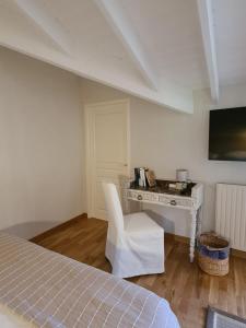 a bedroom with a desk and a bed and a chair at Domaine de la Basse Bobinière - Gîte et Chambres d'hôtes in Thouarsais-Bouildroux