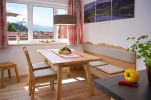 a table and chairs in a living room with a window at 5 Sterne Ferienwohnung Hochgratblick mit Schwimmbad und Sauna in Oberstaufen